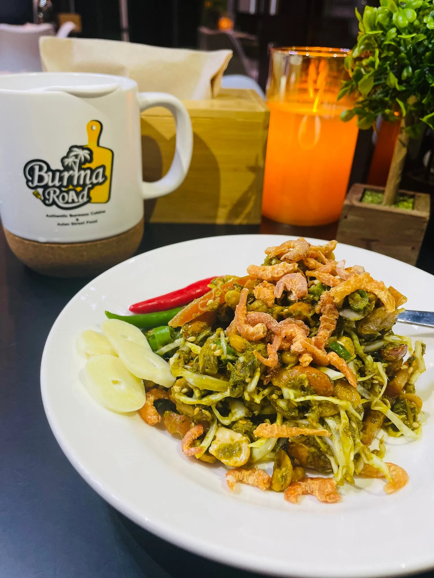 Tea leaf salad on a plate, with crunchy beans, tomato and shredded cabbage